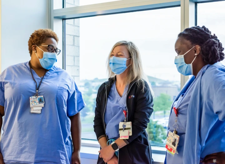 Three UC health team members wearing scrubs.