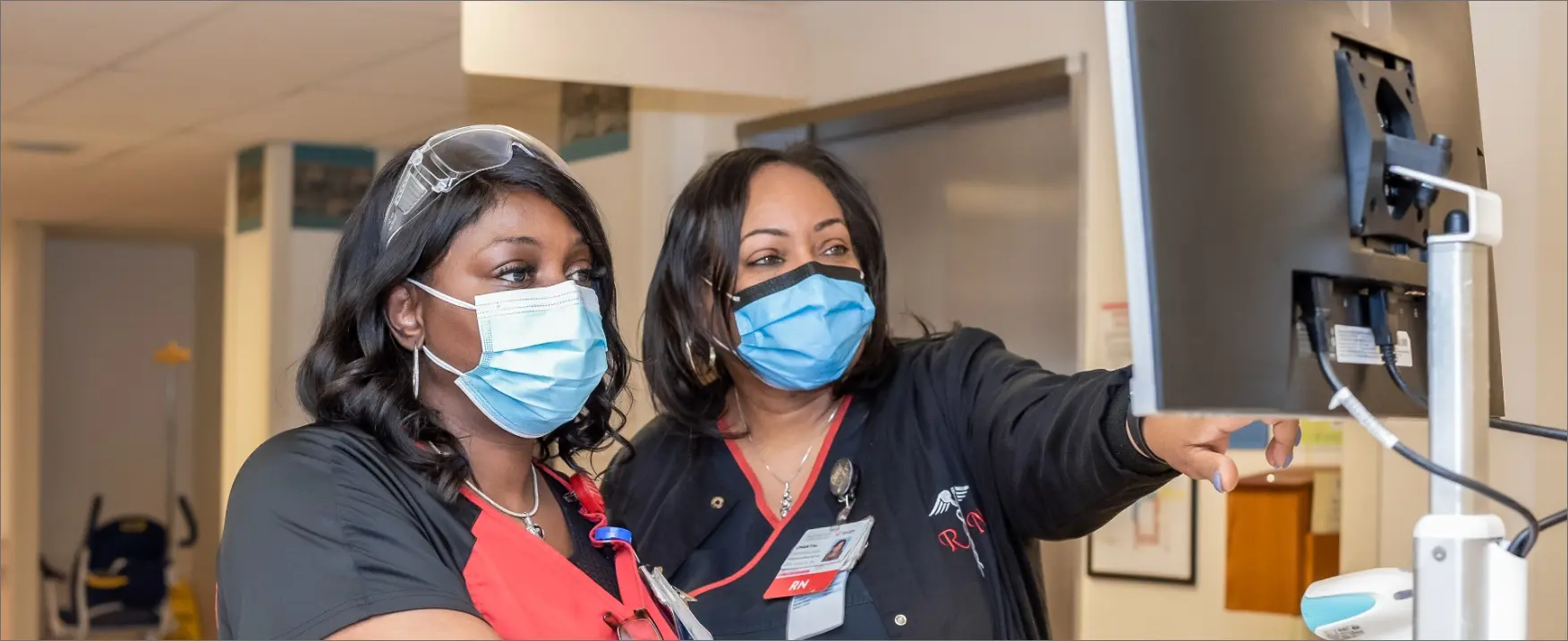 	A female nurse and a nursing manager check a computer screen.