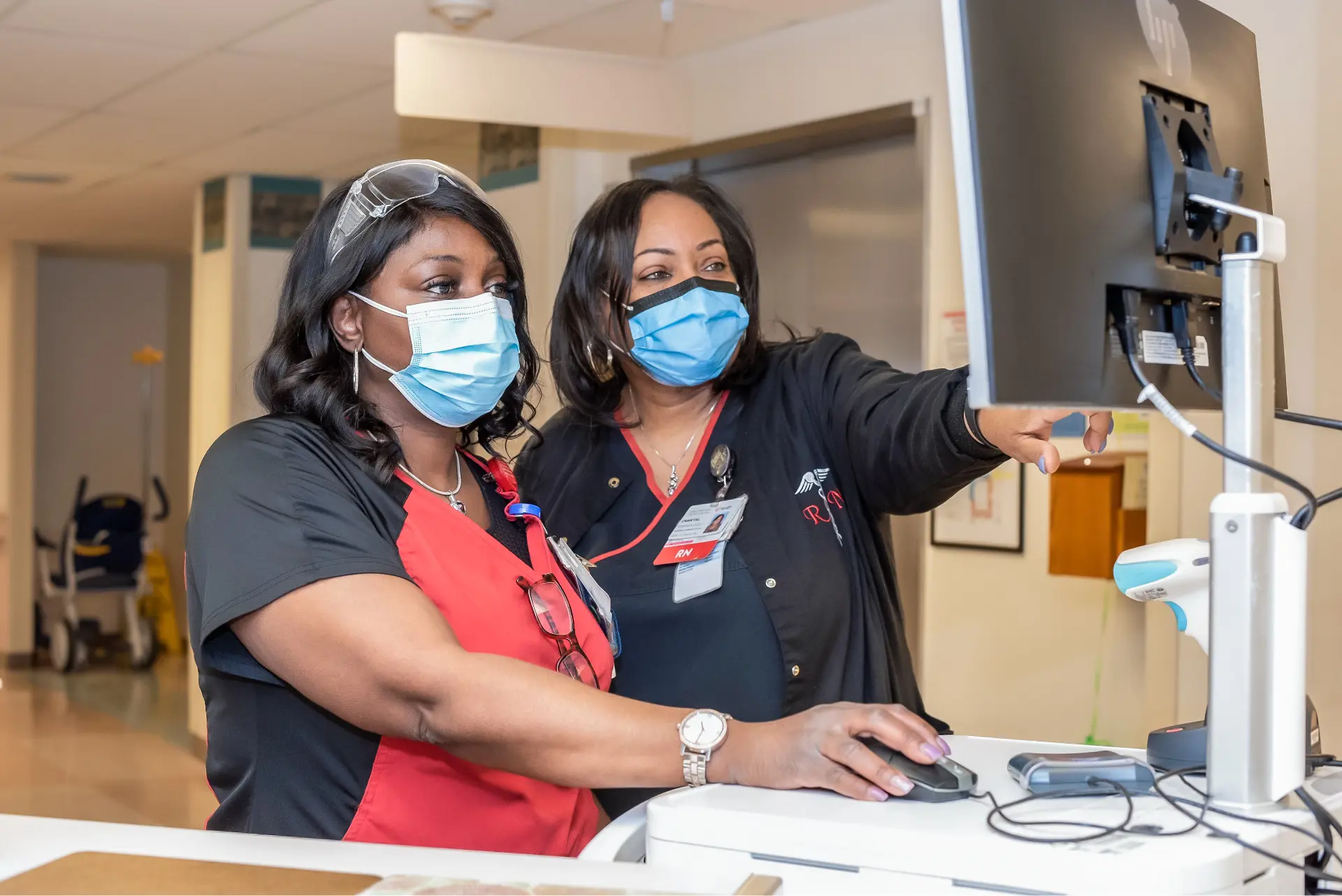 	A female nurse and a nursing manager check a computer screen.