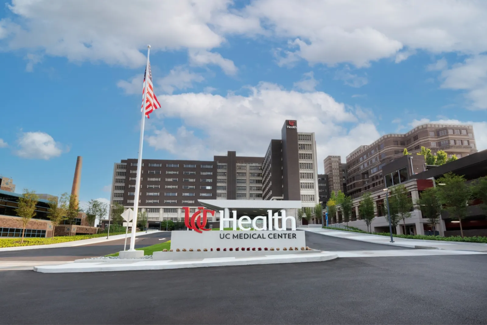 The front of the UC Health Medical Center turn-around lane and building on a bright spring day.