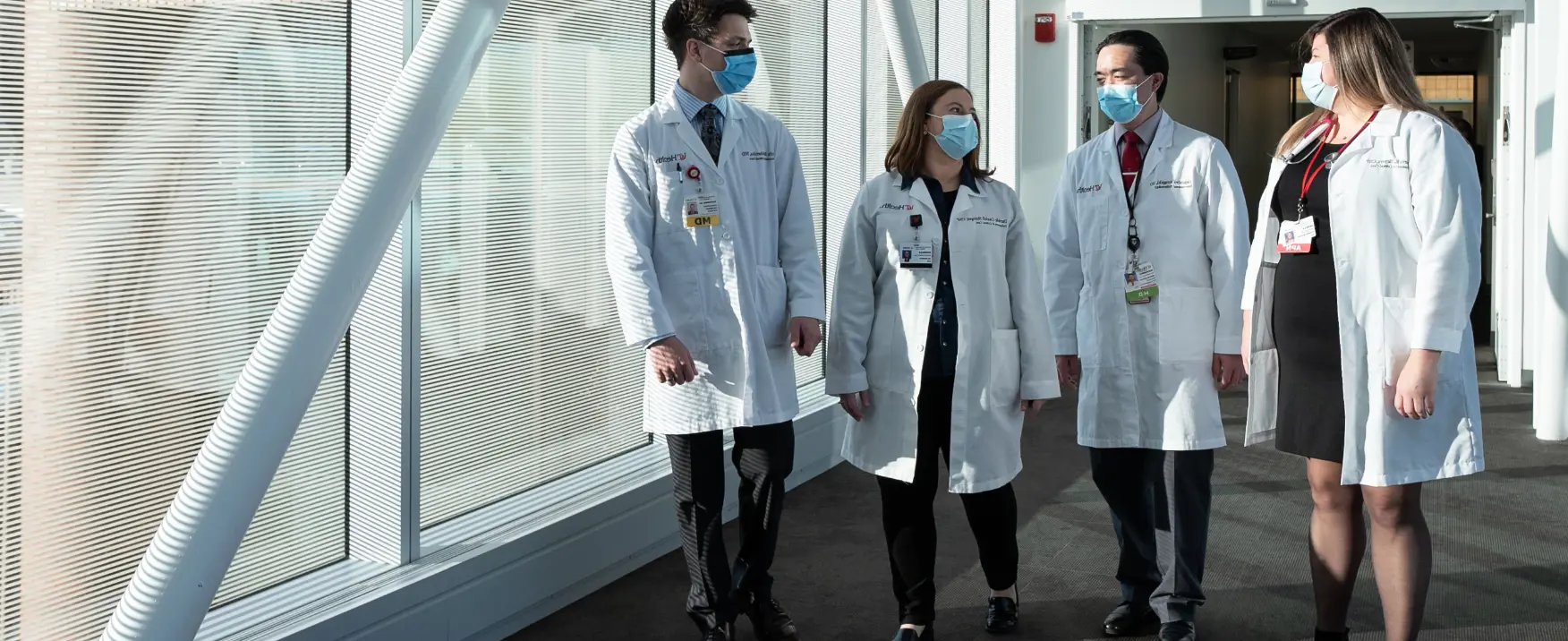  Group of physicians walking on uc health facility 