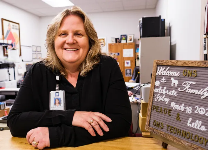 A nutrition team member getting ready to greet students for lunch.