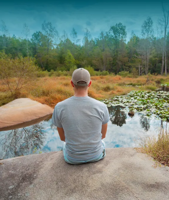 An employee sitting in nature and enjoying the view.