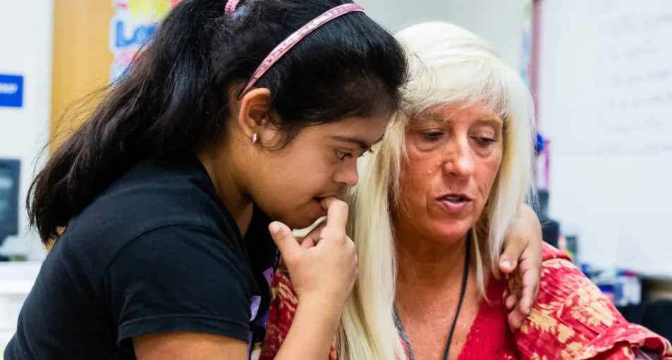 A teacher in special education explaining a task to a student.