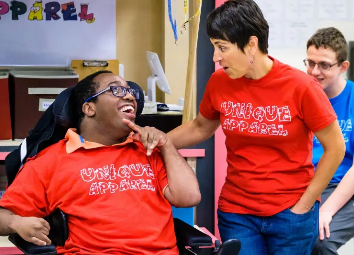 A Special Education Instructional Assistant engaging with a student in class.