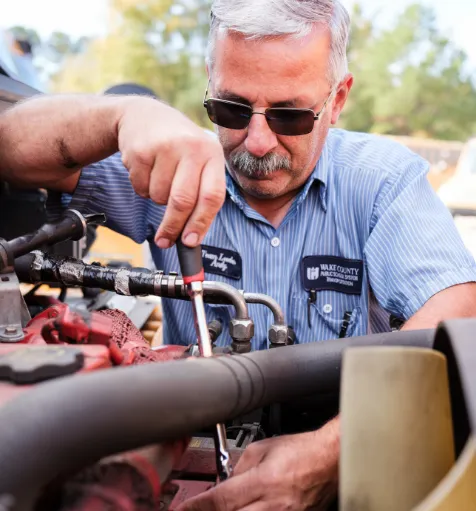 A Bus Mechanic checking on a bus at Wake County Public School system.