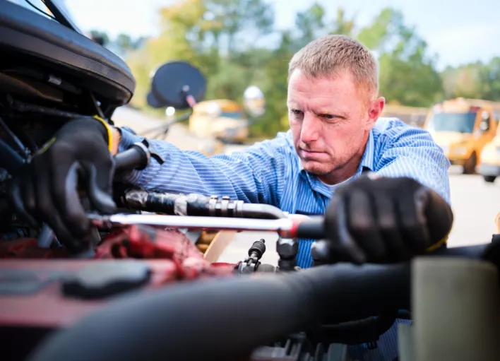 Bus Mechanic tightening a part on a Wake County Public School System bus.