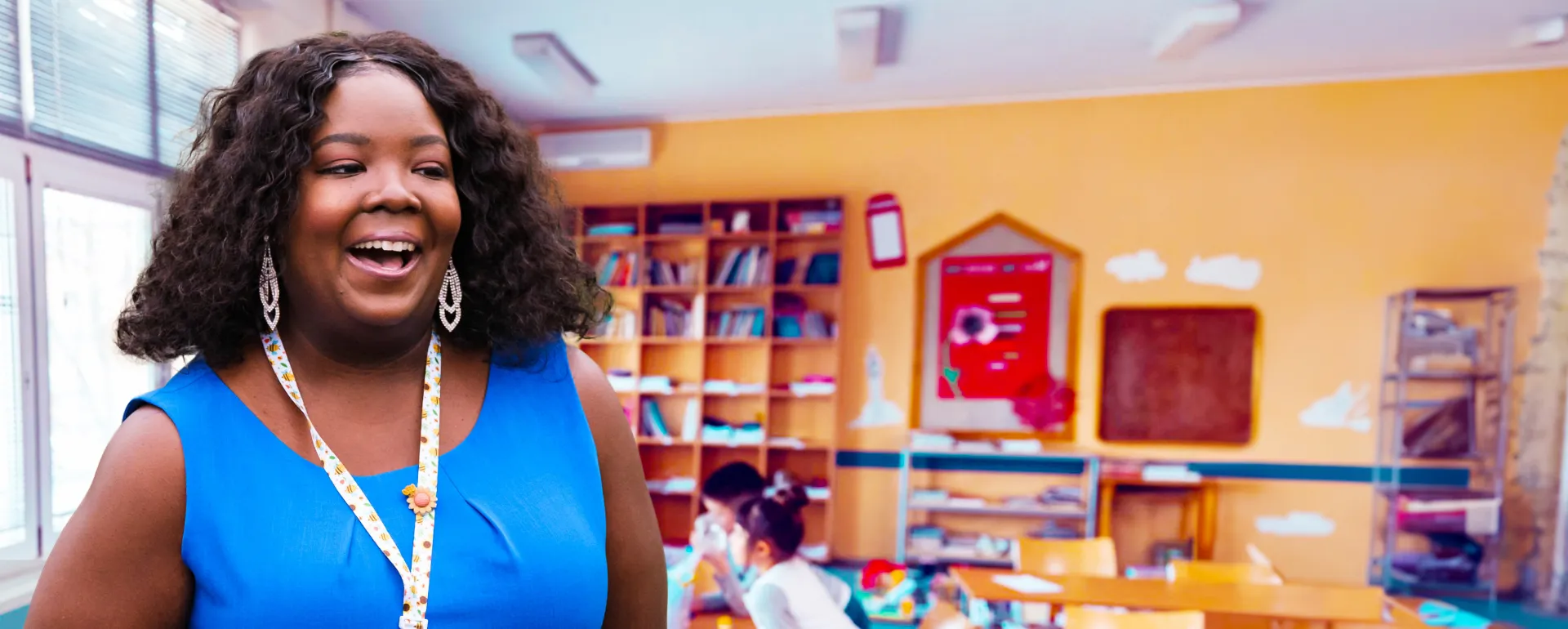 Smiling teacher standing in a classroom.