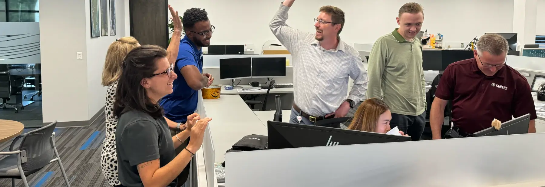 Happy Yamaha employees working together in an office.