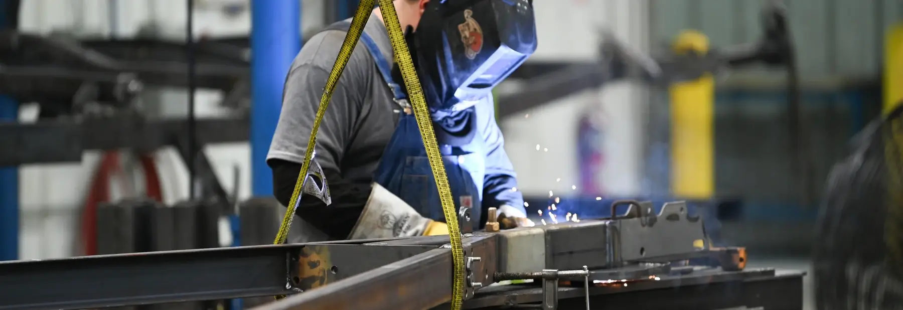 A Yamaha employee welds parts on a manufacturing line.