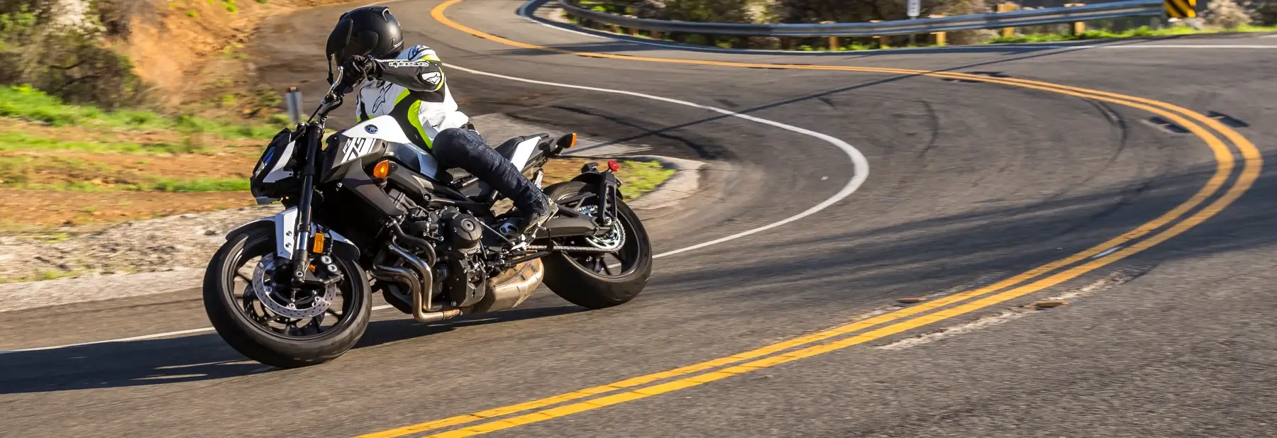 A rider navigating a Yamaha motor bike around a tight turn in the road.