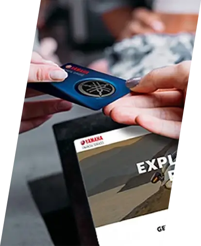 One person handing a Yamaha credit card to another person.