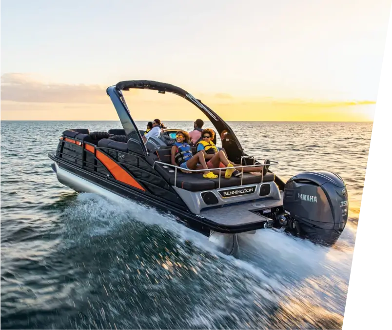 A group of people in a boat enjoying the sunset over the ocean.