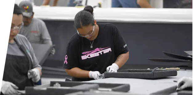 A Skeeter employee assembling a boat in a warehouse.