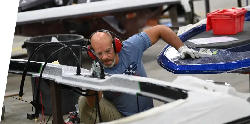 A Skeeter employee assembling a boat in a warehouse.