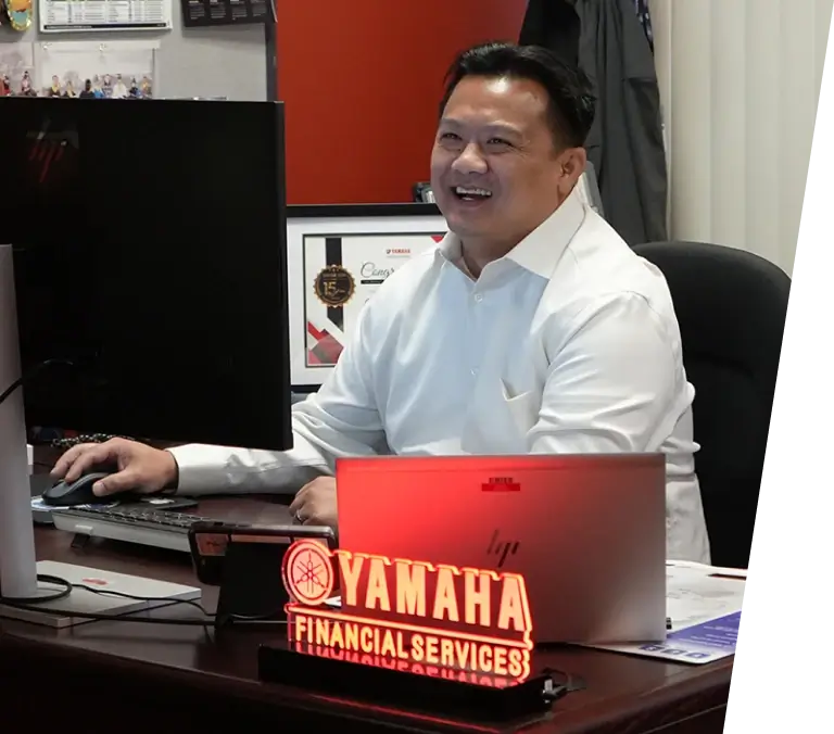 A smiling employee sitting at their desk.