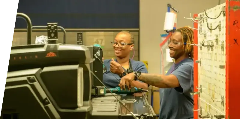 Smiling Yamaha employees working together at a manufacturing facility.