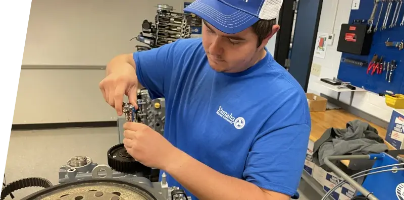 An employee assembling a part at a manufacturing facility.