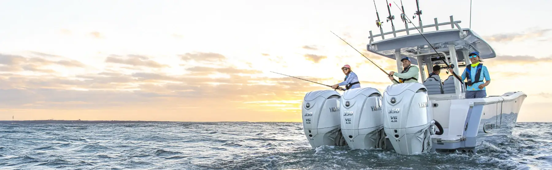 Three people fishing off a watercraft with three Yamaha outboards.