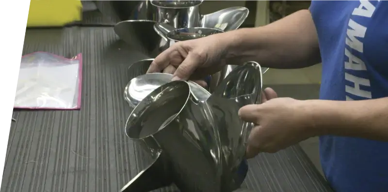 An employee inspecting a propeller at a manufacturing facility.