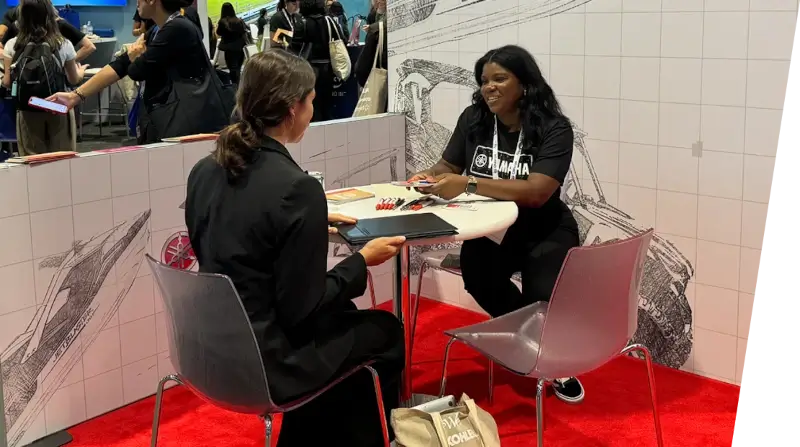 A Yamaha employee interviewing a candidate at an event.