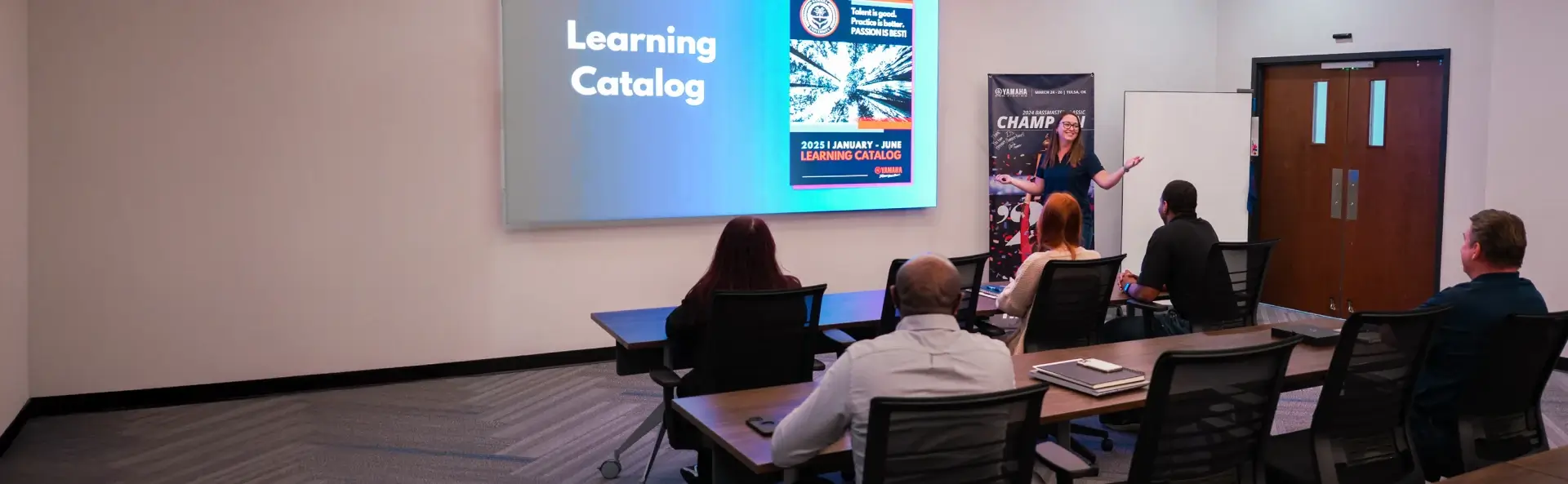 Yamaha employees listening to a speaker present during company training.