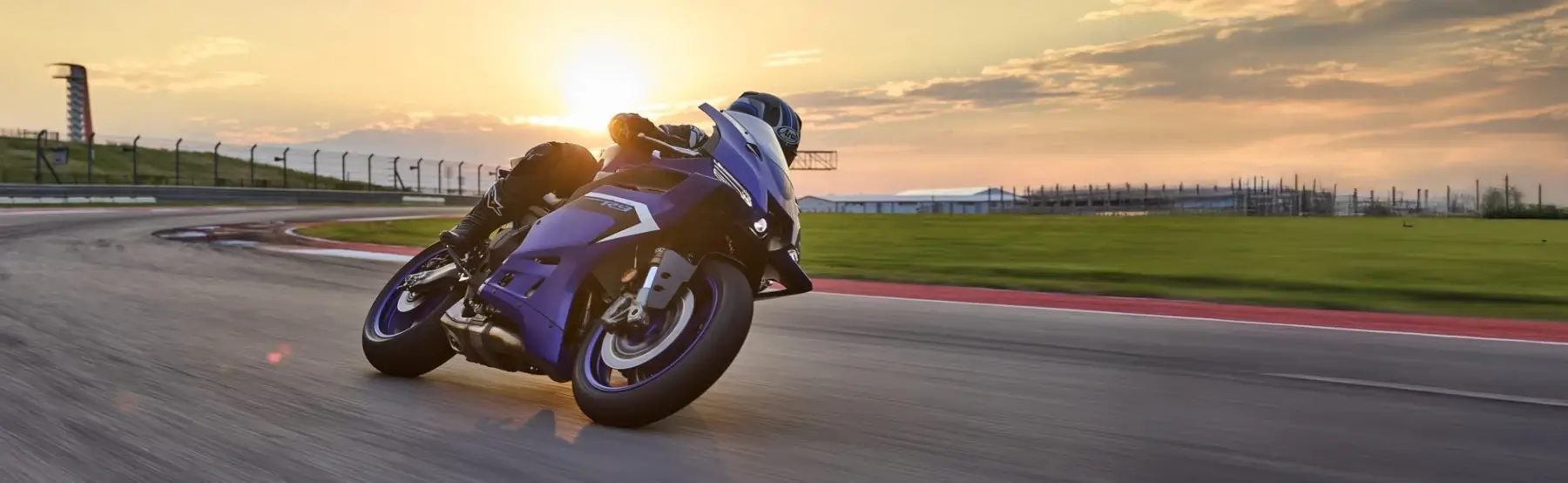 A rider driving a Yamaha R-9 motorcycle on a race track.
