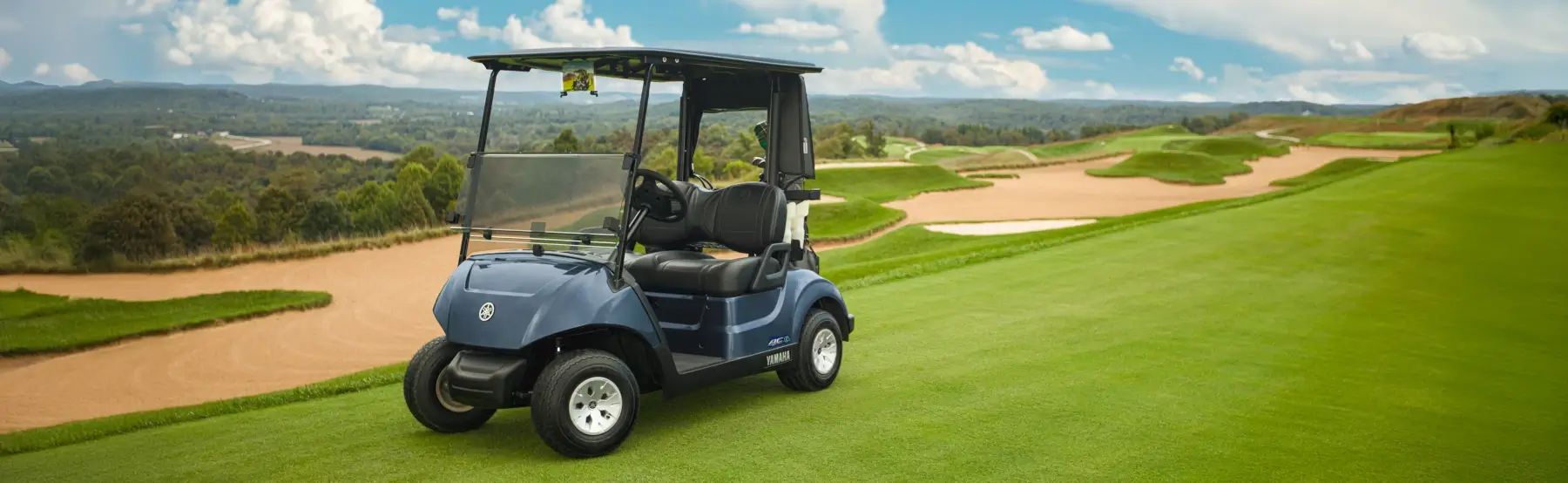 A Yamaha golf car on the green of a golf course.