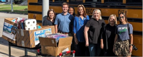 A group of Alliance team members standing next to a table of donation boxes.