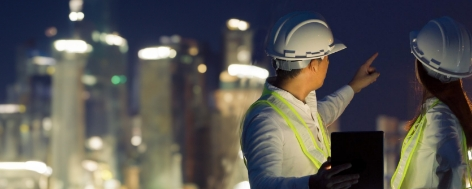 Two technicians holding a tablet and pointing offscreen.