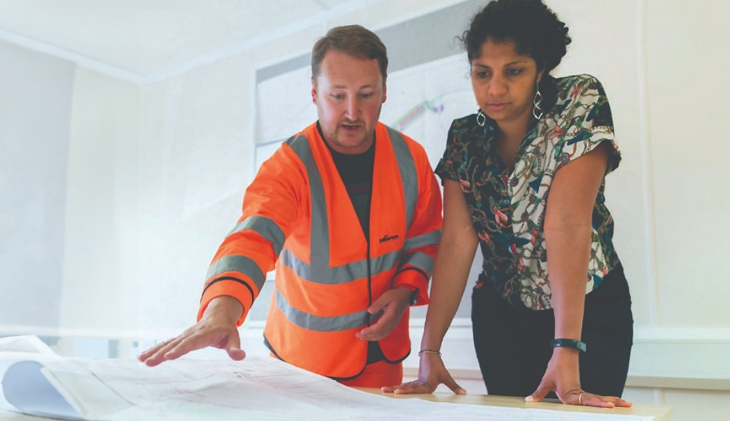 Two employees leaning over a map in discussion.