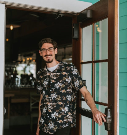 A Bahama Breeze employee carrying plates and smiling