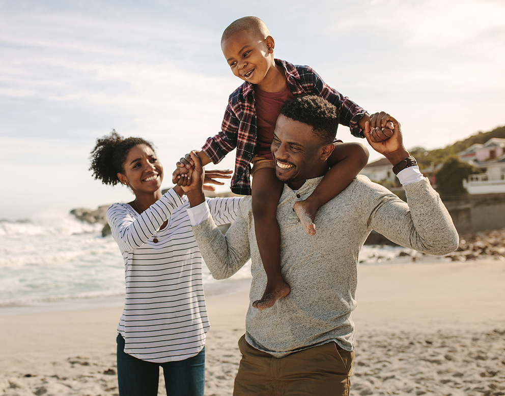 A family smiling on the beach.