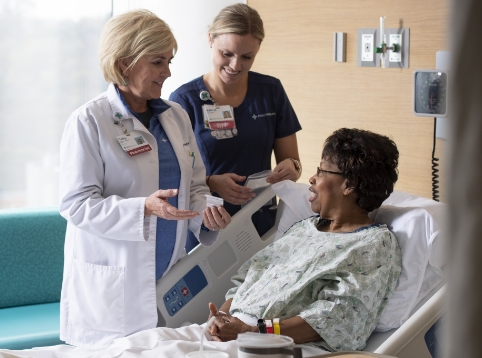 Bon Secours Mercy Health physician and nurse attending a patient at the bedside