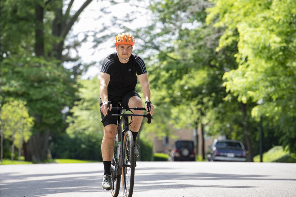 Man with helmet riding his bike on a suburban street