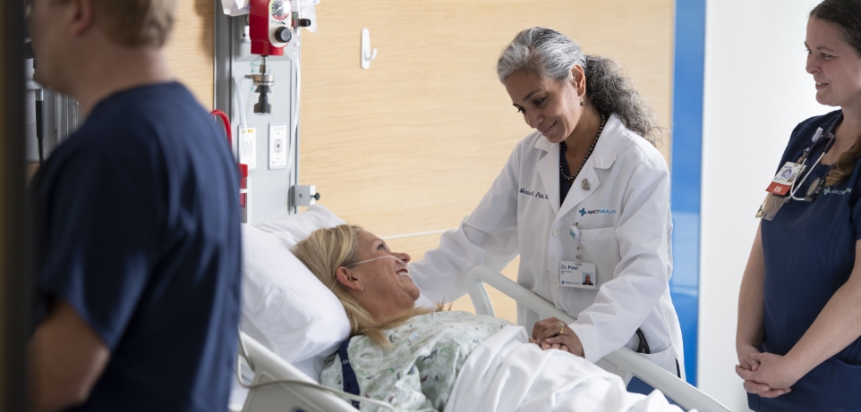 Bon Secours Mercy Health physician comforts patient at the bedside