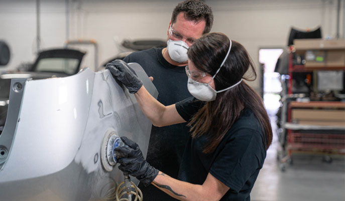 Two Boyd emploees buffing the car hood surface