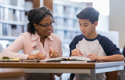  	An adult employee helping a child with homework.