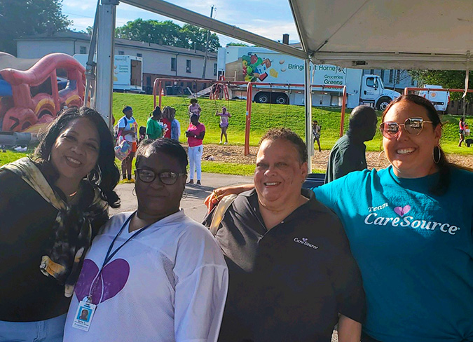 Employees smiling during the outdoor event at CareSource