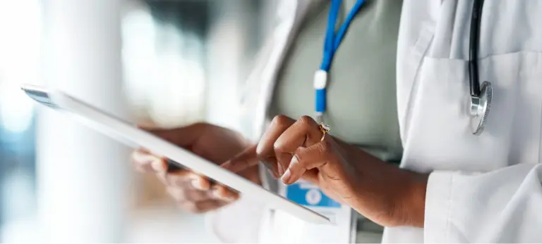 A physician reviewing a document on an tablet.