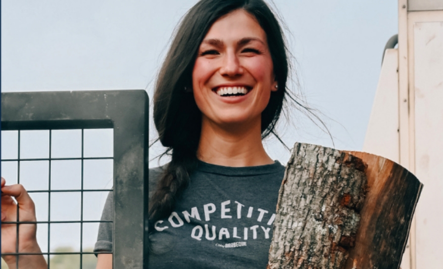  	An aspiring City BBQ female employee enjoying work as a pitmaster.