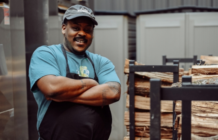  	City BBQ employee smiling about his job.