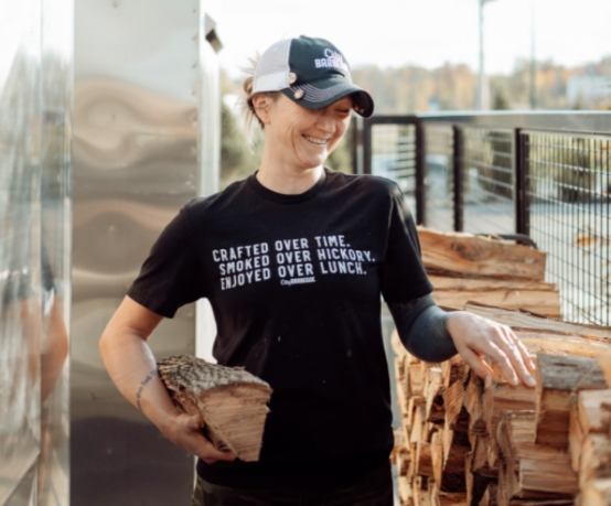 A City Barbeque employee carrying more wood to the smokers.