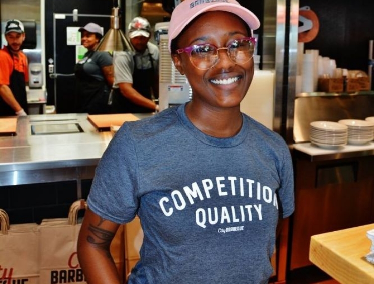 A happy City Barbeque employee working in food service.
