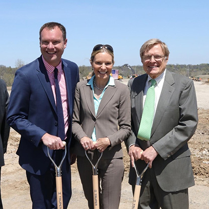 Three members of Dierbergs leadership standing together, smiling and holding shovels.
