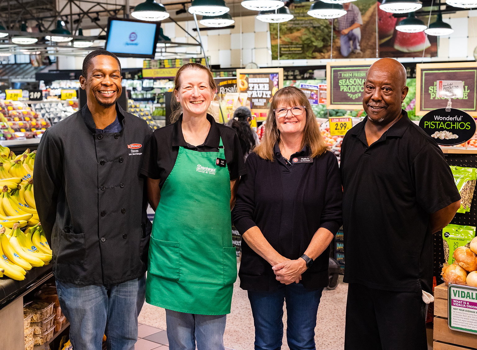 Four Dierbergs employees smiling and standing next to one another in a store.