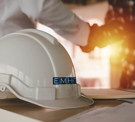 A hard hat with the EMH&T company logo.