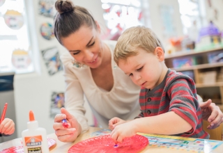 An educator painting with a student.