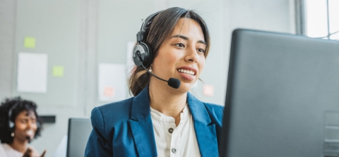 Two corporate professionals smiling and helping their team.