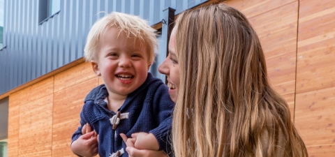 A woman and two young children smiling.